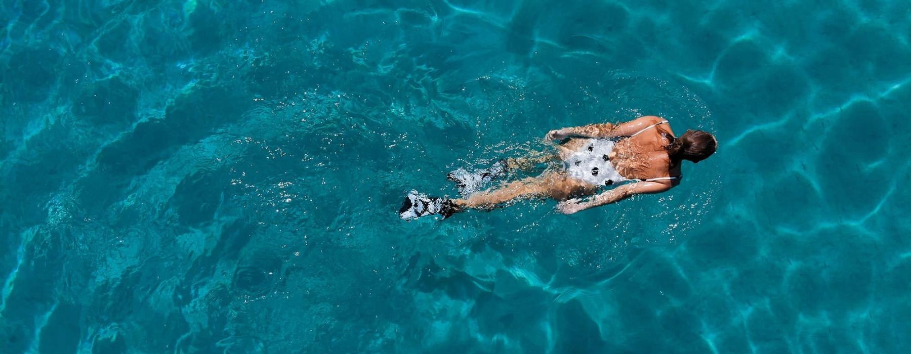 overhead shot of a woman swimming in a pool